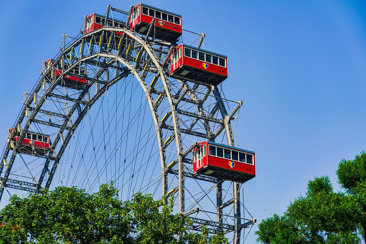 Iconic view of the Vienna Giant Ferris Wheel (Wiener Riesenrad) at Prater amusement park, Austria, illuminated against the sky, symbolizing Vienna's rich history and vibrant entertainment scene.