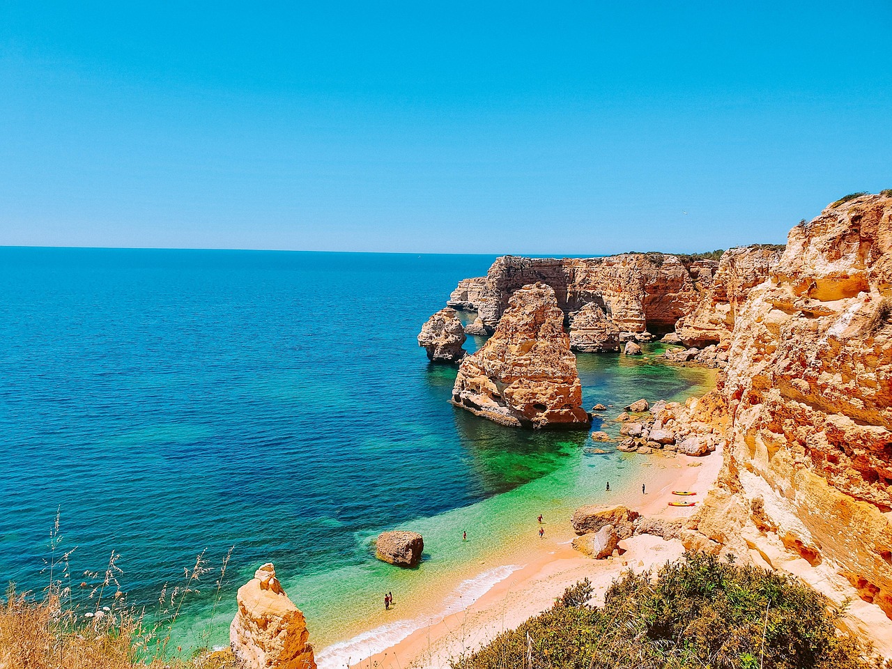 The golden cliffs and turquoise waters of Praia da Marinha, Algarve.
